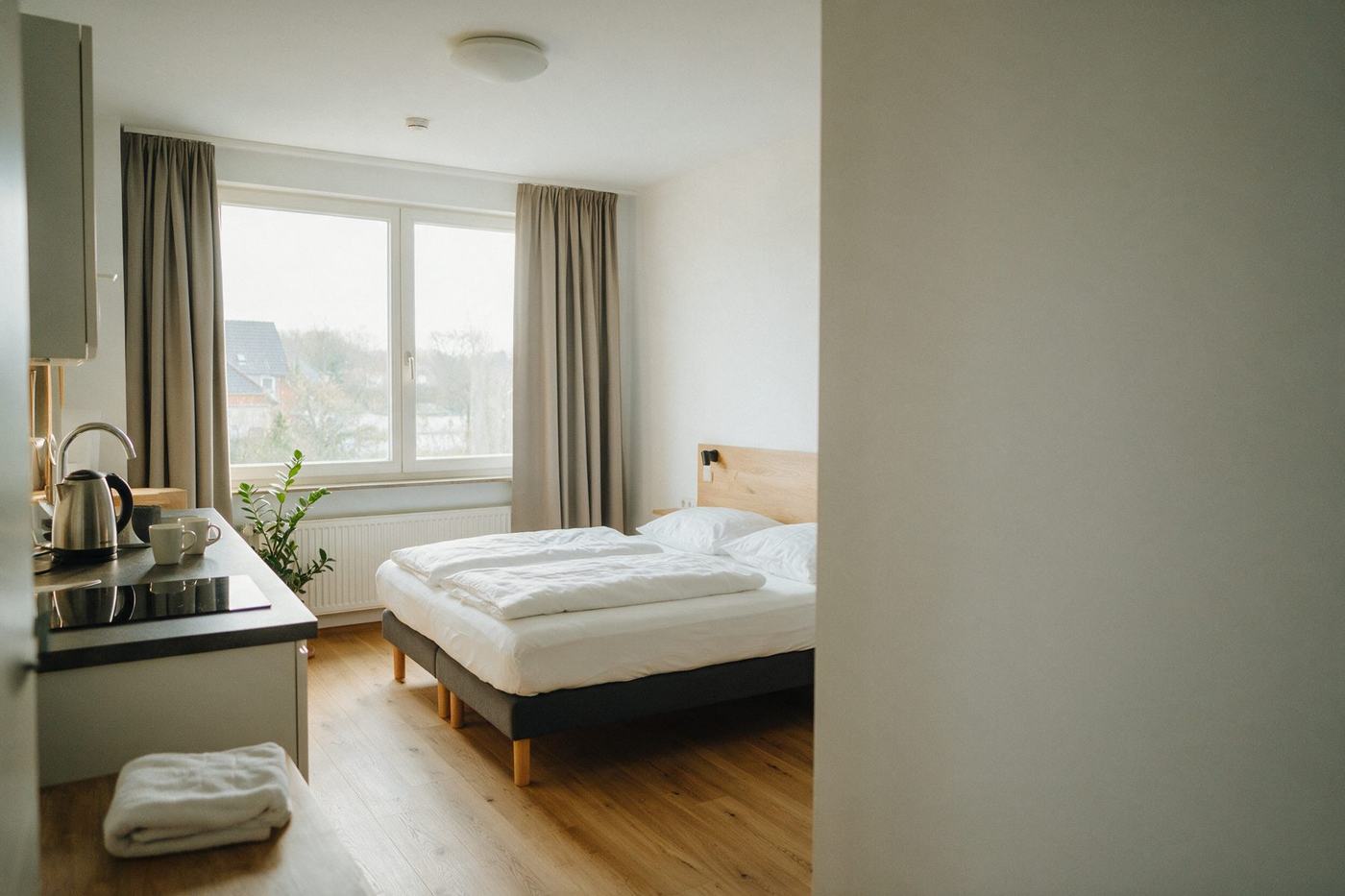 Licht appartement met tweepersoonsbed en kleine keuken, 's ochtends